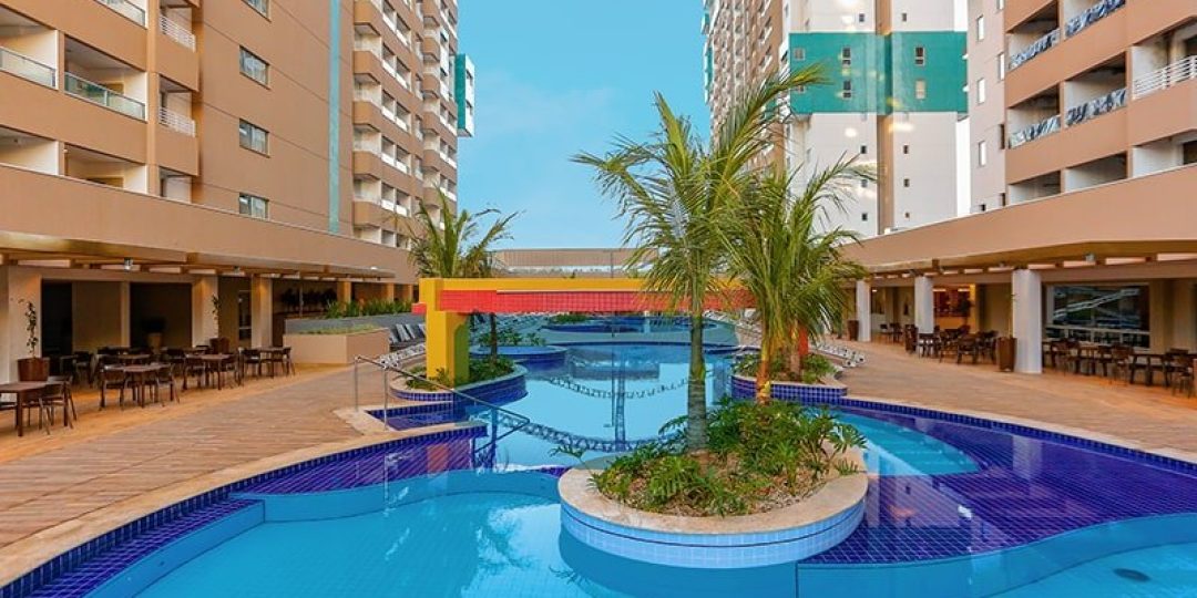 Piscina com ilha de coqueiros no Enjoy Olímpia Park Resort